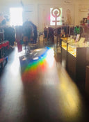 Interior of a store with clothing racks and a rainbow effect on the floor