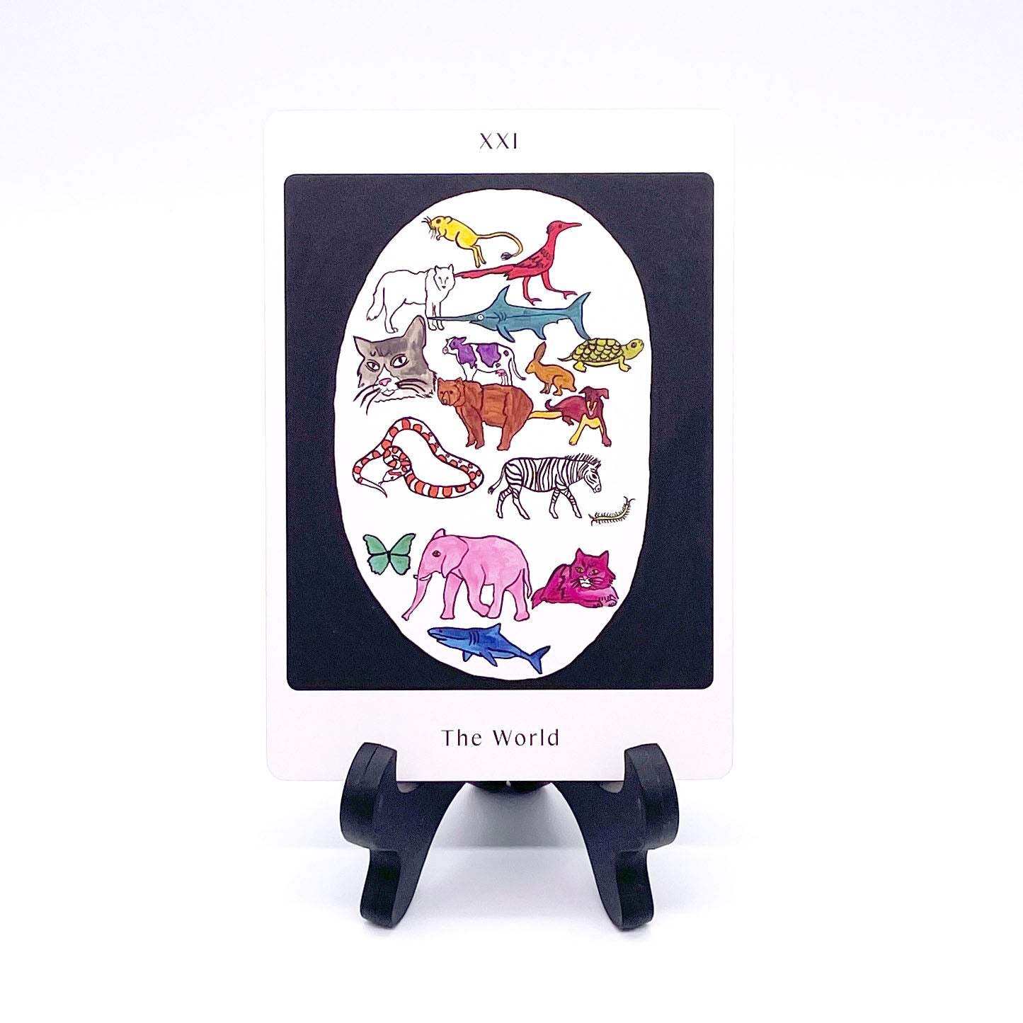 The World card showing a multicolored menagerie of animals in a white oval surrounded by a black background. Card is printed with the title and corresponding Major Arcana number "XXI".