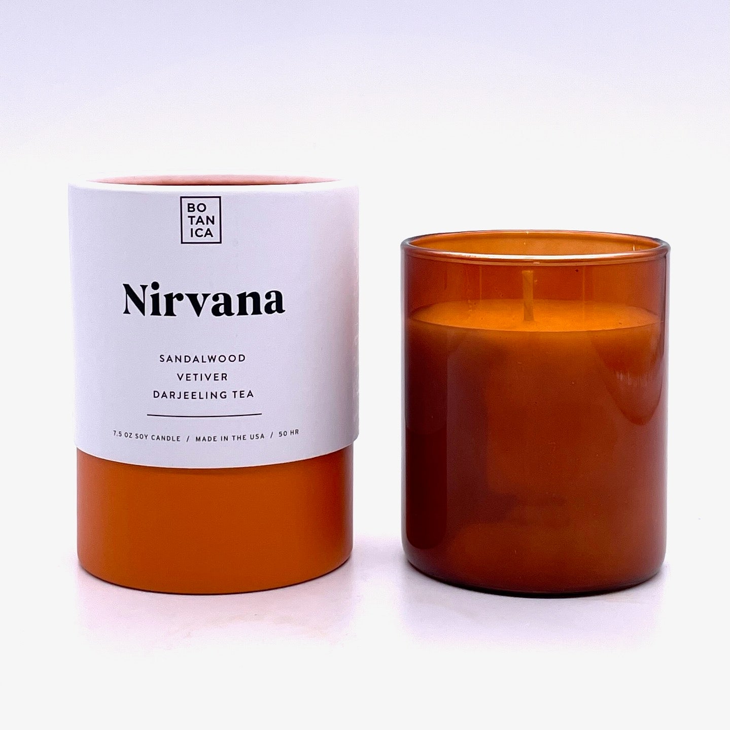 Amber Glass Candle next to White & Orange Tube Package with Black Text
