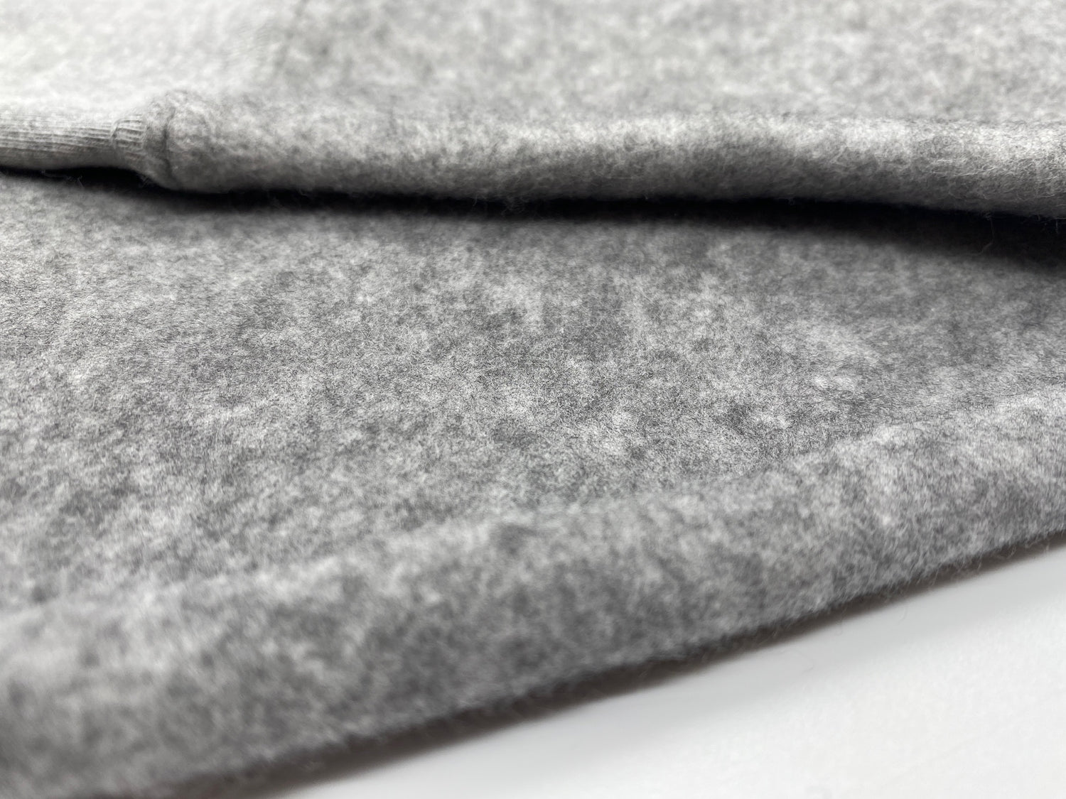 Close up of sweatshirt fabric, showing tufted, fuzzy texture.