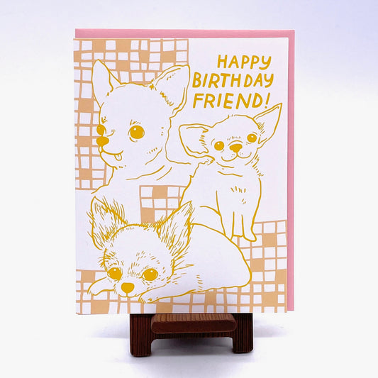 Birthday Card, hand drawn images of chihuahuasin yellow and beige ink on a white background with a pink envelope. Says "Happy Birthday Friend!"
