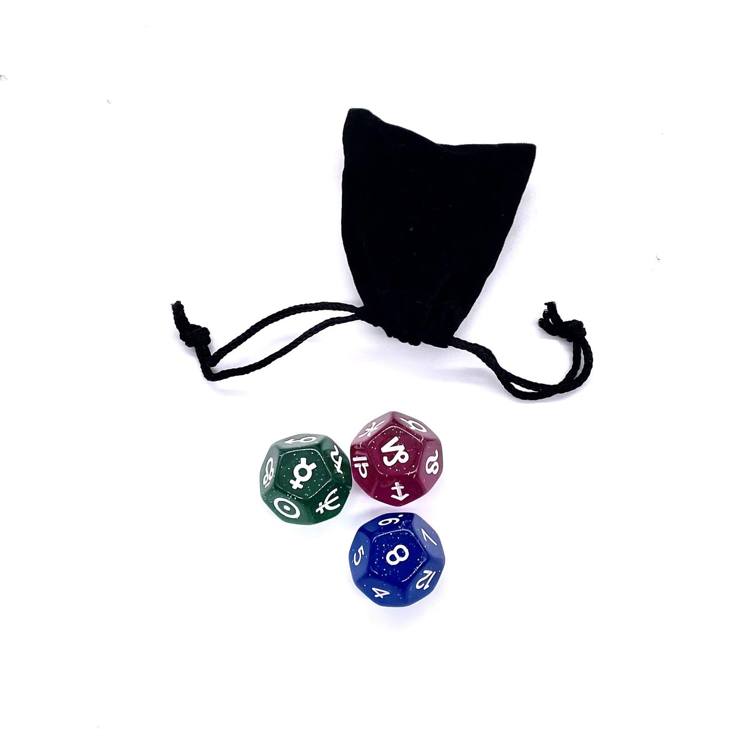 Three astro dice next to a black velvet pouch.