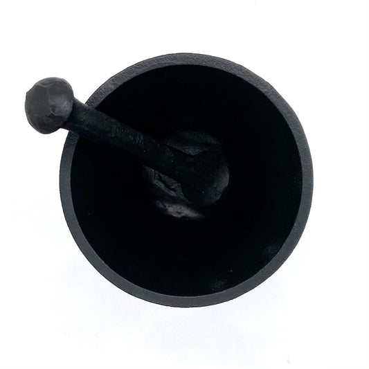 Top view of black cast iron mortar and pestle ritual bowl.
