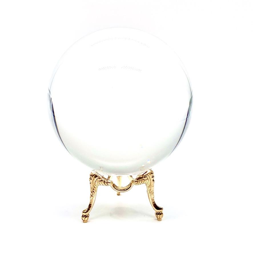 Large crystal ball on gold stand.