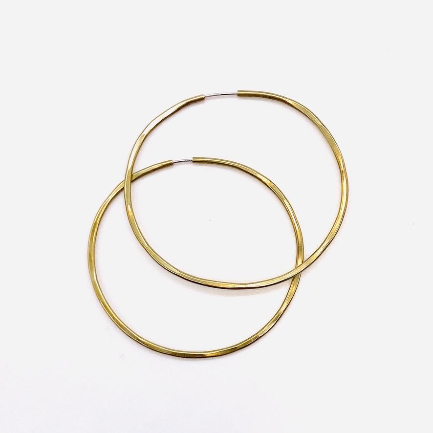 Brass geometric hoop earrings in solar 3-inch shape.