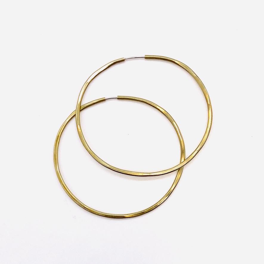 Brass geometric hoop earrings in solar 3-inch shape.