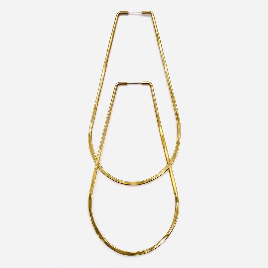 Brass geometric hoop earrings in una large shape.