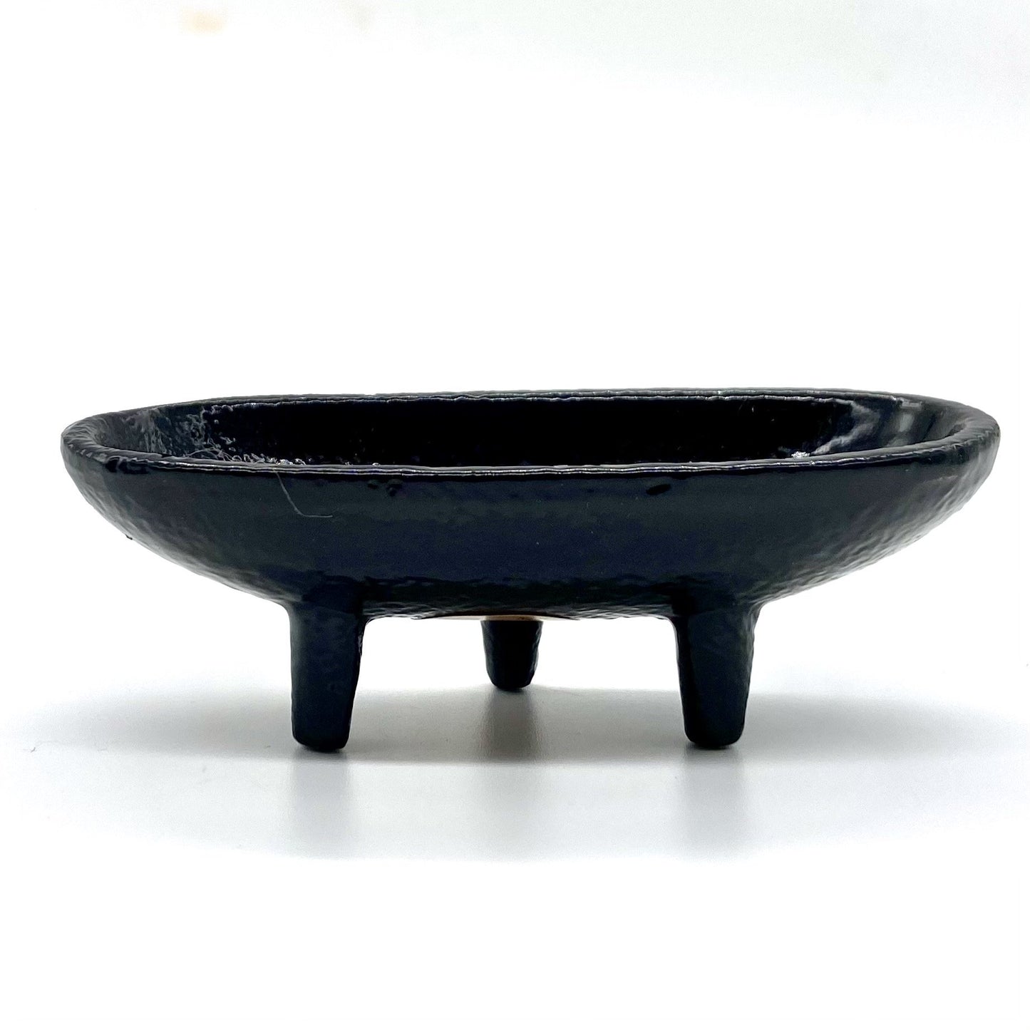 Cast iron incense burner in boat shape with legs.