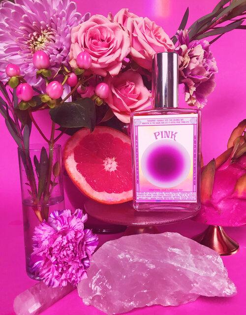 Moon Nectar Vibrational color spray in pink displayed with flowers and crystals.