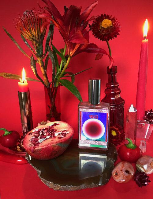 Moon Nectar Vibrational color spray in red displayed with flowers and crystals.