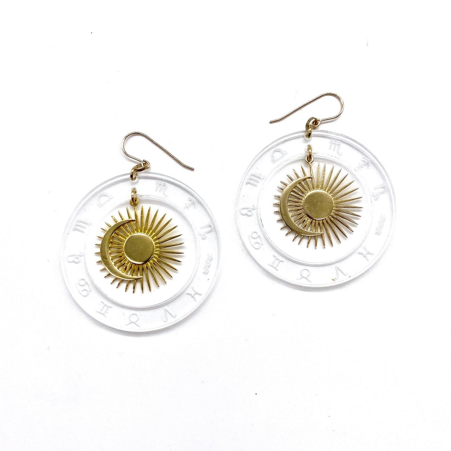 Lucite and brass hoop earrings with celestial zodiac design.